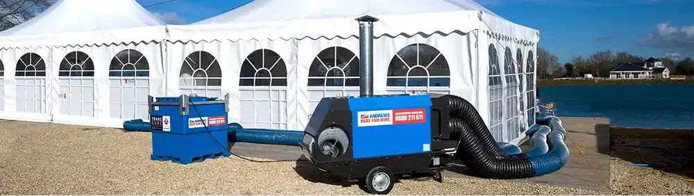 Portable indirect oil-fired heater providing temporary heating for an outdoor marquee event.