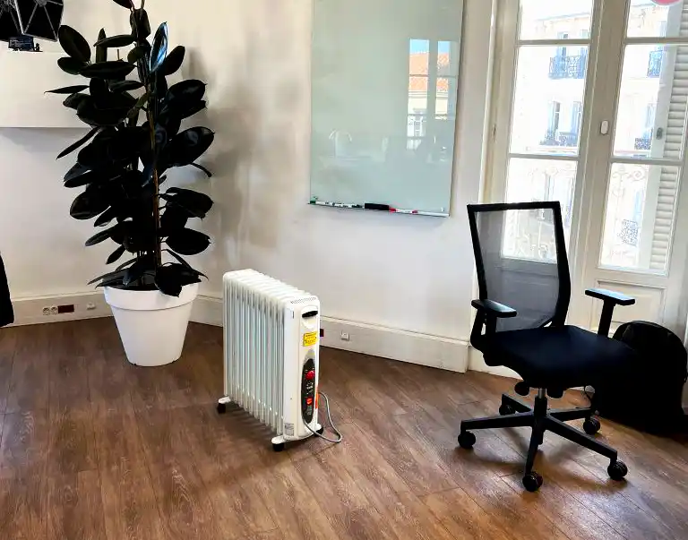 Oil-filled radiator heater providing safe and low-noise temporary heating in an office environment.