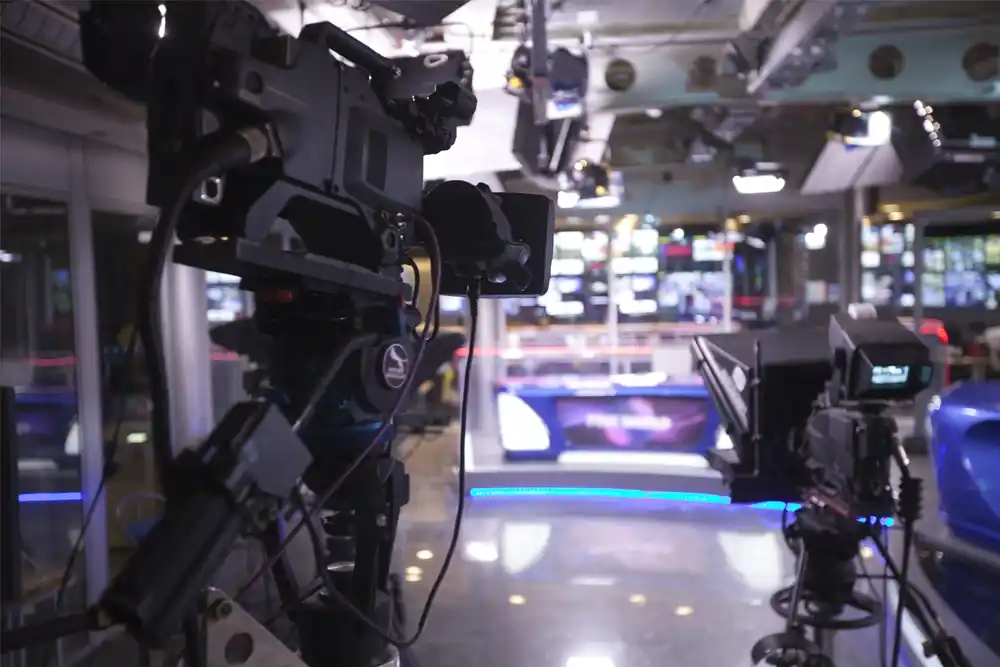 Behind the scenes at a broadcast television studio with multiple cameras, demonstrating a high-tech environment that requires silent, fume-free climate control.