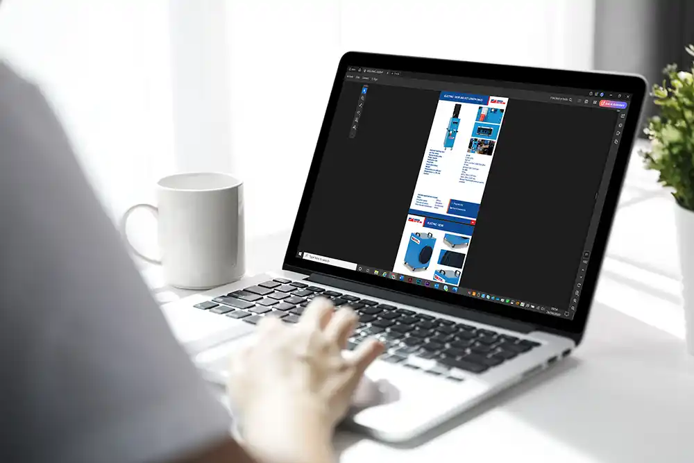 A person using a laptop to view the digital version of the Andrews Sykes product guide, showing specifications for various electric heater models.