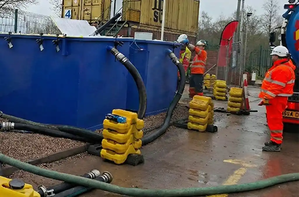Engineers installing a temporary water treatment system to manage hydrocarbon-contaminated water during emergency remediation works at a live petrol station site.