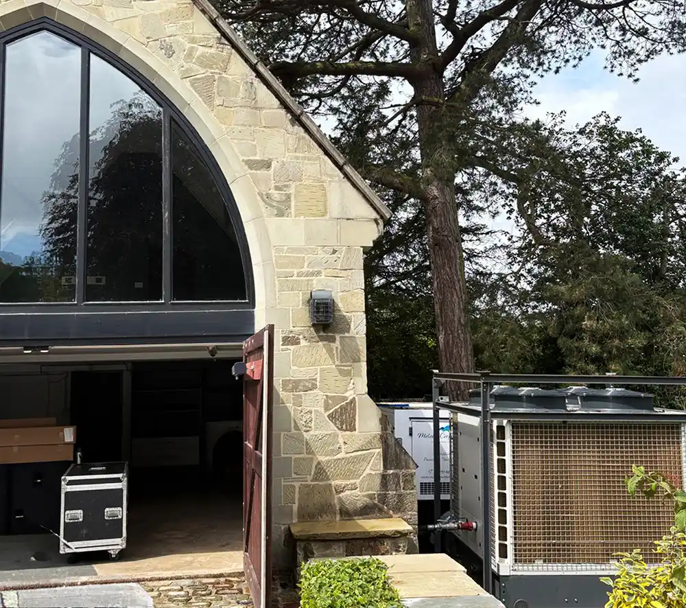 Chiller Unit Positioned Outside the Wedding Venue Chiller unit discreetly positioned outside a stone-built wedding venue, supplying cooling to the air handling units inside the marquee