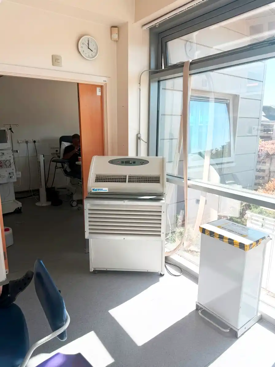 https://www.andrews-sykes.com/wp-content/uploads/2026/08/Temporary-Cooling-for-NHS-Renal-Unit.webp PAC22 portable air conditioner supplying clean cooled air for dialysis patients in healthcare environment
