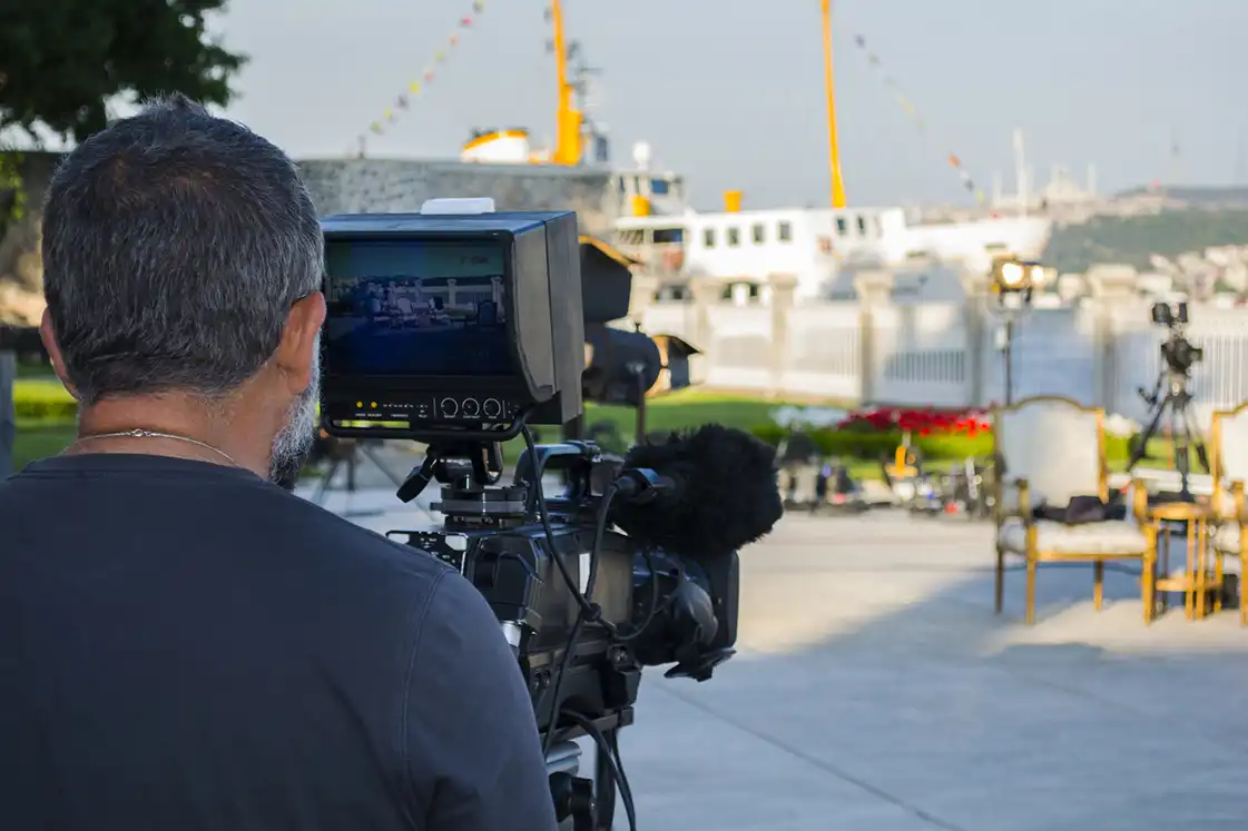 filming on location for a television production A camera operator monitors a live outdoor shot during filming for a television production