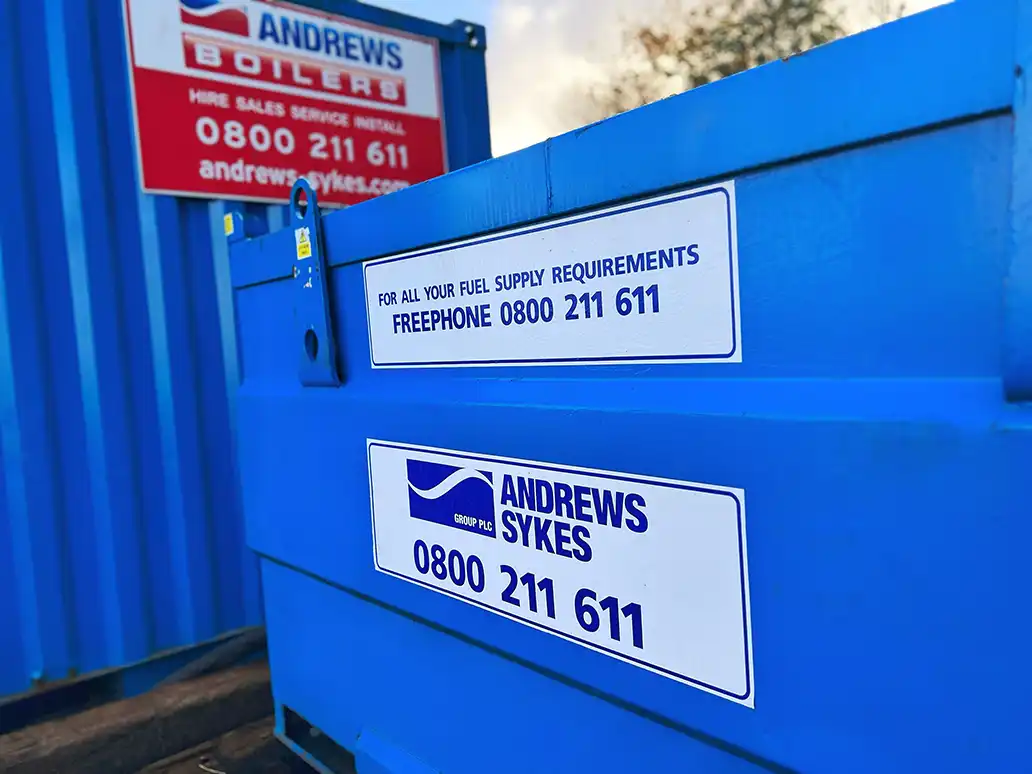 Andrews Sykes fuel tank for HVO supply Andrews Sykes fuel tank beside a Packaged Boiler, with signage for fuel supply enquiries on freephone 0800 211 611