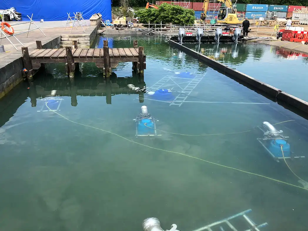 pump and flow equipment set up in a film set water tank Submersible pumps and outboard-mounted flow equipment positioned in a large water tank on a film production backlot