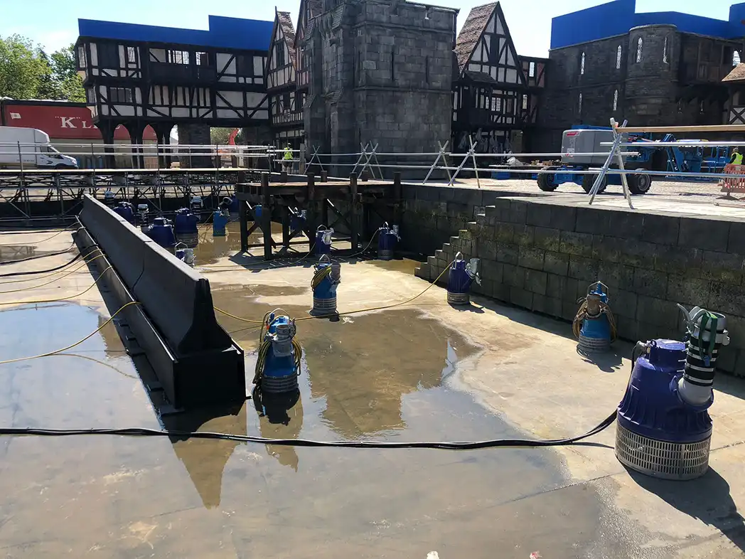submersible pumps positioned in a castle moat film set Multiple submersible pumps positioned around a dewatered stone moat on a UK film and TV production backlot