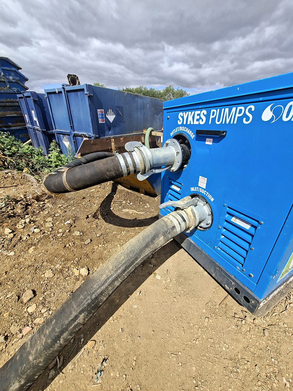 Super Wispaset 100 super silenced pump with suction and discharge hoses, transferring reservoir water to temporary storage on a construction site