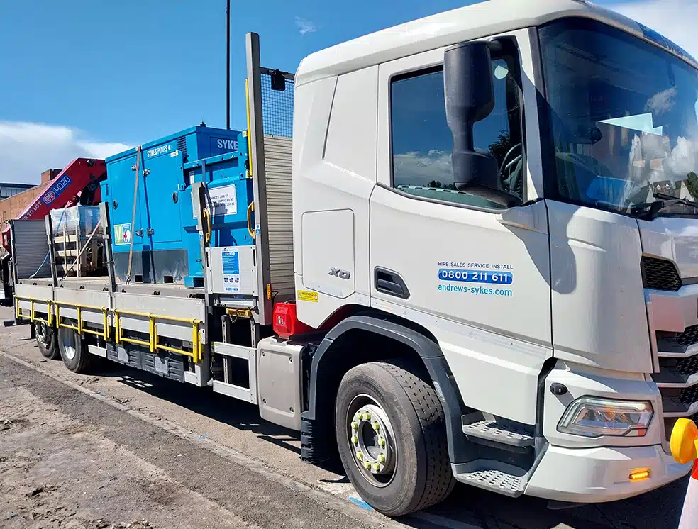 Andrews Sykes lorry delivering a Sykes pump Andrews Sykes crane lorry delivering a Sykes super silenced pump and bunded fuel tank to a construction site for temporary pumping